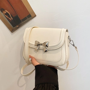 Chic cream white crossbody bag with silver bow accent and adjustable shoulder strap