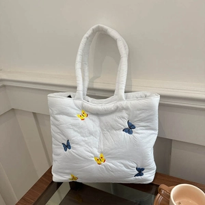 White quilted tote bag with colorful butterfly embroidery for daily commute and casual use