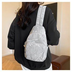 Silver wrinkled crossbody bag featuring multi-pocket storage shown on a model