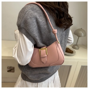 Détail du sac sous les aisselles rose en demi-lune avec boucle dorée et nœud de bandoulière