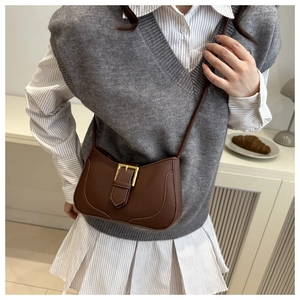 Détail du sac demi-lune rétro marron avec boucle dorée et fine bandoulière en cuir