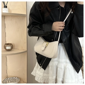 Détail d'un sac sous le bras en cuir blanc cassé avec boucle carrée dorée élégante