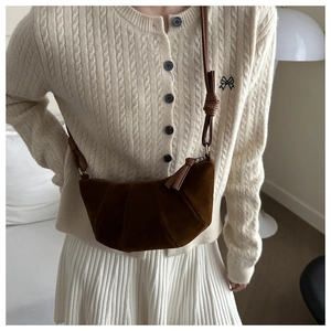 Detail of dark brown matte croissant bag with pleated design and knotted leather strap