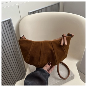 Detail view of caramel brown pleated crescent bag featuring soft suede texture and zippers