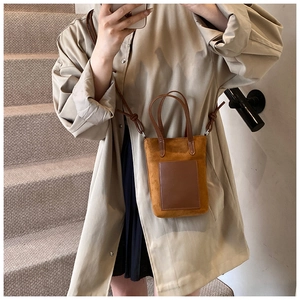 Detailed view of a vintage brown crossbody phone bag with matte texture and dual handles