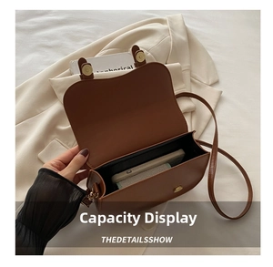 Détails de l'intérieur d'un sac besace marron montrant sa capacité de rangement