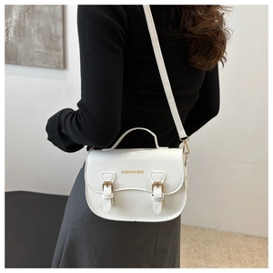 Vue de dos du modèle portant un sac selle blanc en similicuir avec boucles cœur