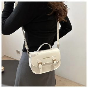 Vue détaillée d'un sac besace en cuir blanc avec doubles boucles et poignée haute
