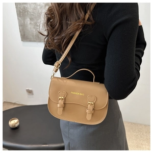 Détail d'un sac à main rétro marron clair avec boucle en métal en forme de cœur