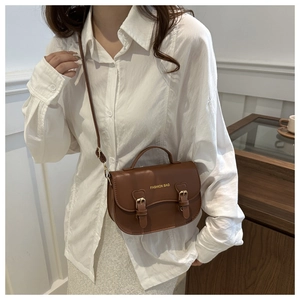 Détail du sac besace marron vintage avec texte fashion et fermeture à double boucle