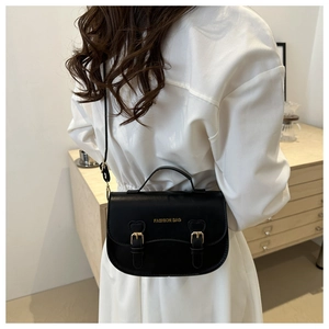 Détail d'un sacoche noire en cuir avec boucles dorées et lettrage doré Fashion Bag