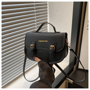 Détail du sac à main noir en similicuir avec boucles dorées et texte de mode chic