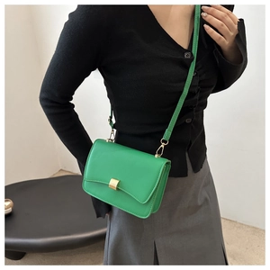 Detail of the bright green minimalist crossbody bag with elegant gold metal clasp