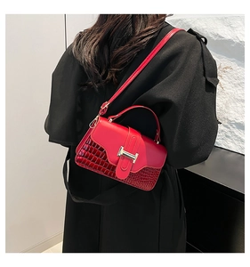 Detailed view of red crossbody square bag with gold H-clasp and crocodile texture