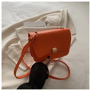 Vibrant orange leather crossbody bag featuring a classic gold metal square buckle