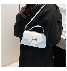 Detail view of white crossbody bag with crocodile texture and golden H buckle closure