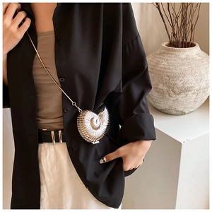 Macro shot of silver nautilus-shaped mini bag with metallic texture and chain