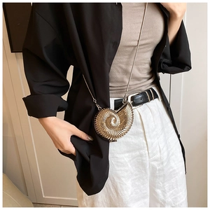 Detail of champagne gold nautilus-shaped mini crossbody bag with metallic spiral texture