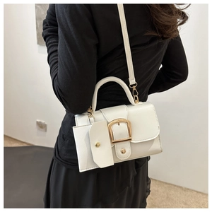 Detail van de witte lederen crossbodytas met gouden gesp en klein afneembaar tasje