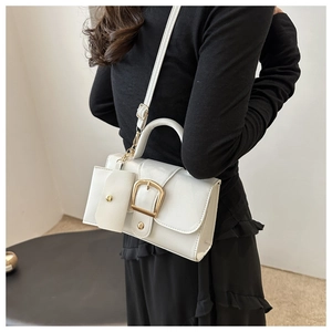 Detail van witte crossbodytas met litchi-textuur, gouden gesp en een mini-portemonnee
