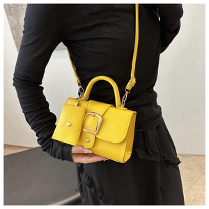 Chic yellow mini square bag with matching coin purse and gold buckle on a black outfit