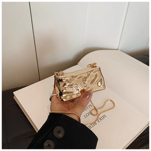 Close-up of golden metallic mini bag with textured pleats and fine snake chain
