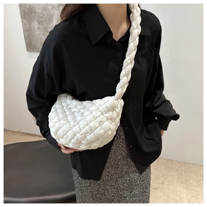 Detalle del bolso de nube acolchado blanco con textura plisada y correa trenzada elegante