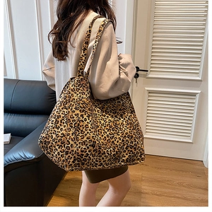Detailed view of the large leopard print canvas tote bag styled on a person's shoulder