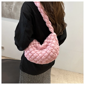 Vista detallada del bolso de nube acolchado rosa con correa trenzada gruesa y textura suave