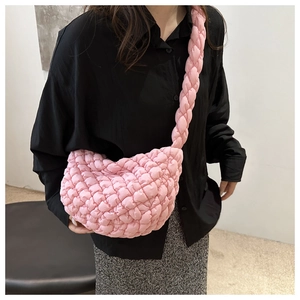 Detalle de bolso acolchado rosa con correa trenzada y textura de burbuja muy suave