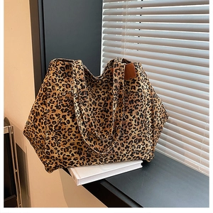 Leopard print canvas tote bag detail featuring premium texture and brown leather side tag