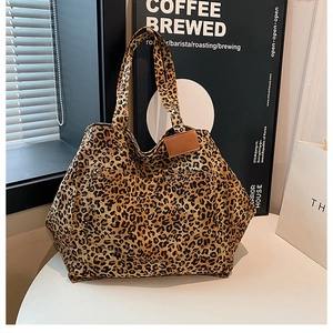 Detailed macro of leopard print canvas tote bag with a brown leather logo patch