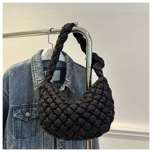 Détail du sac hobo matelassé noir avec une texture gaufrée et broderie bouffante