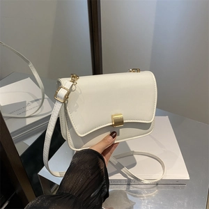 Minimalist white leather crossbody bag with gold buckle and stylish flap cover design
