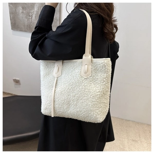 Dettaglio della borsa tote in pile bianco con tracolla in pelle color crema e cuciture
