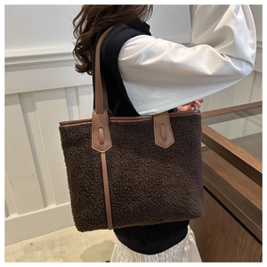 Dettaglio della borsa tote in peluche marrone con manici in pelle per moda autunnale