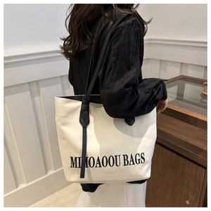 Lifestyle-Foto einer minimalistischen cremefarbenen Canvas-Tote-Bag mit schwarzem Aufdruck