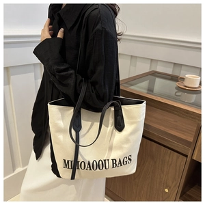 Detailaufnahme der minimalistischen Canvas-Tasche mit schwarzen Lederriemen zu Hause