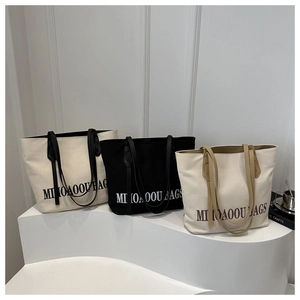 Three minimalist canvas tote bags in white and black shown in a professional studio setup