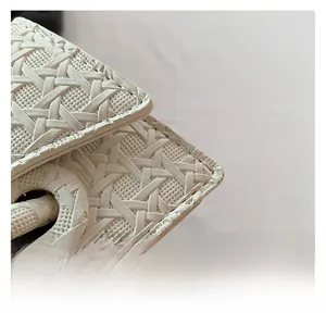 Macro detail of white woven texture with intricate grid patterns on a stylish handbag