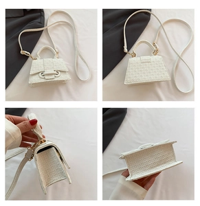 Detail view of white trapezoid handbag with woven texture and gold metal hardware