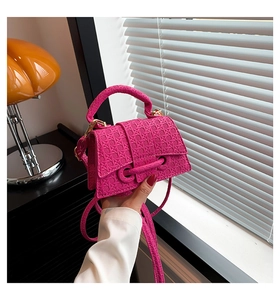 Detail of woven texture on hot pink mini crossbody bag with gold hardware