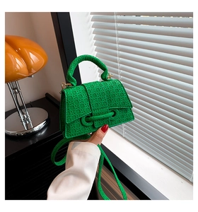 Detail of bright green woven texture and metallic clasp on stylish handbag with strap
