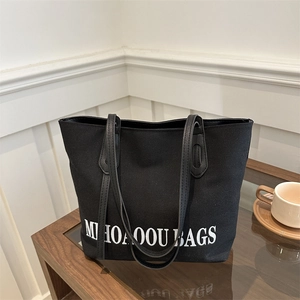 Minimalistische schwarze Canvas-Einkaufstasche mit Buchstabendruck und Lederriemen