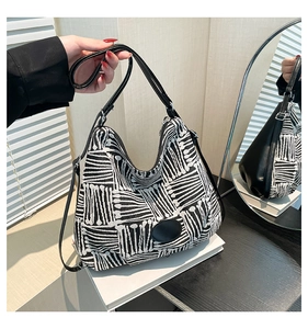 Détail du sac hobo avec imprimés géométriques noirs et blancs et bandoulière en cuir