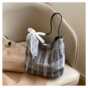 Close-up of black and white checkered handbag with delicate lace and a large white bow