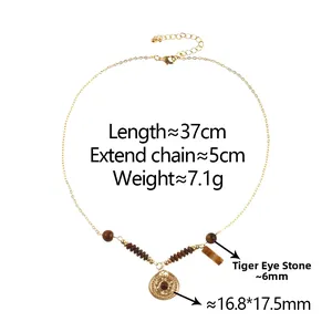 Detail of gold chain necklace with round pendant, tiger eye stone and brown beads