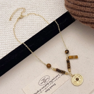 Vintage gold necklace with tiger eye stone beads and embossed circular pendant detail