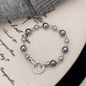 Close-up of grey pearl bracelet featuring a sparkling zircon-encrusted round clasp