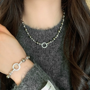 Elegant grey pearl necklace and bracelet set with pavé zircon round clasp on a model